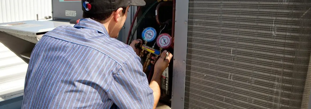 HVAC technician servicing a condenser unit in Waxahachie